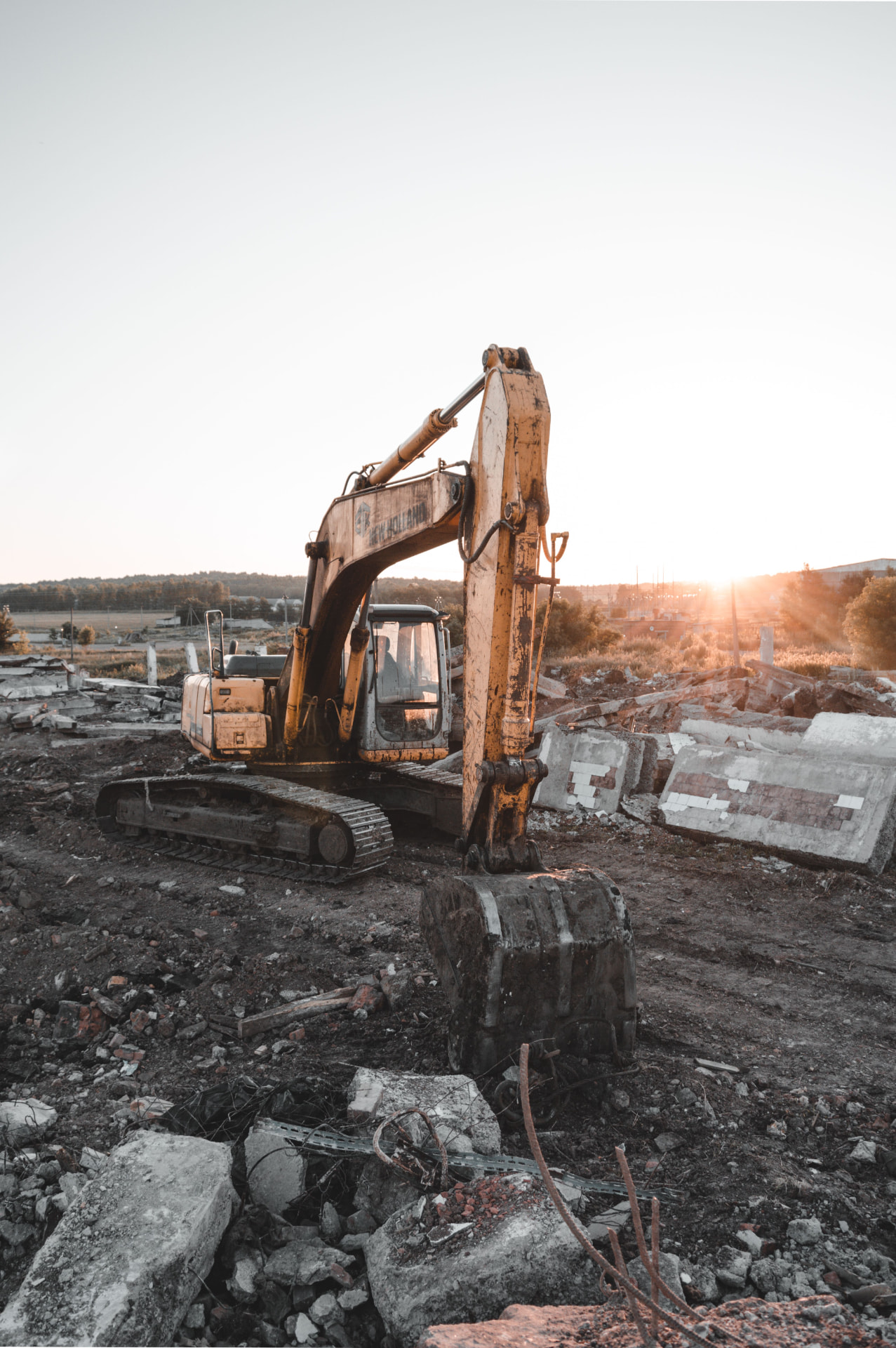 Excavator on a demolition and earthworks site at sunset
